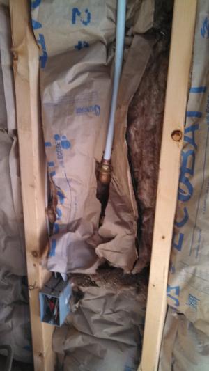 Wrong - Craft faced batt insulation is compressed behind PEX pipe instead of being sliced to fit around it.