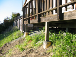 A deck or other attached structure located at the top of a slope with vegetation underneath is at high risk of ignition during a wildfire