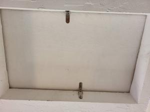 Latches were added to this attic access panel to hold it more tightly against the weatherstripping for better air sealing when closed.