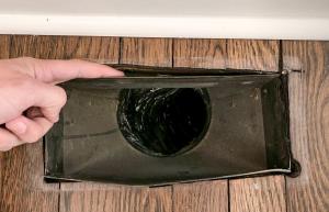 This air register has noticeable gaps between it and the floor; use canned spray foam to fill in the gaps.