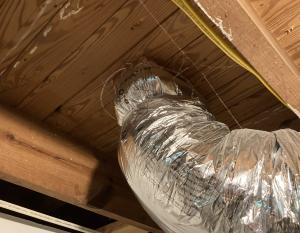 Ductwork, like this insulated flex duct, penetrates the subfloor where there are floor registers on the floor above 