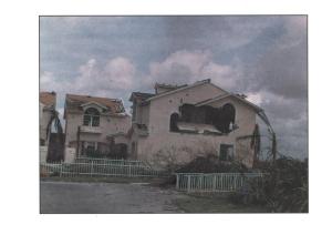 Failure of a freestanding concrete masonry end wall due to discontinuous tie-beam when exposed to hurricane force winds. 