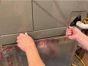 The furnace filter slot cover should fit tightly to minimize air leakage but it should not be taped or caulked to enable frequent filter replacements.