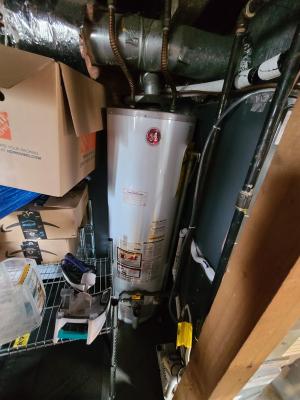 This water heater is hidden behind stored items in the basement.