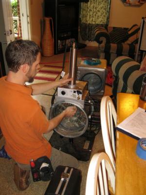 A technician assembles the spray sealant injection system to seal HVAC ducts from the inside