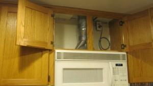 Install the fan either in the range hood, the cabinet above the stove, or on the wall above the stove