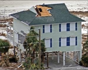High winds pulled the asphalt shingles and sheathing panels off this coastal home, although storm shutters protected the windows