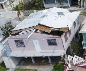 High winds pulled part of the roof off this gable-roofed home.