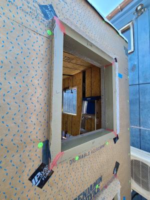 Right - Corners of window are protected with draining house wrap that laps onto the sides of the window trim, paint-on flashing at window trim corners, and self-adhered flashing to reinforce corners.