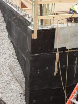 Effectively manage below-grade water in urban sites to prevent moisture issues in new and existing buildings. This foundation wall has been waterproofed to prevent water infiltration.