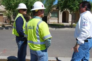 A builder meets with utility staff at a job site.