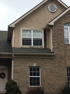 Wrong - Missing kick-out flashing to divert rainwater runoff into the gutter where the roof meets the wall has caused discoloration and water damage behind the stucco next to this second-story window.