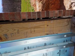 Wrong - Mortar is clogging 1" drainage gap behind brick wall.