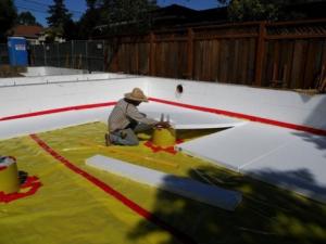 Right--The polyethylene ground cover for this insulated crawlspace is taped at seams and around posts before the insulation and slab are installed. 
