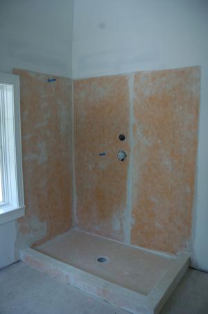 A water-resistant backer board is installed behind the shower tiles.