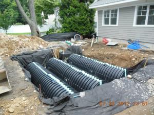 A storm water management system channels rainwater to retention chambers buried in the front yard.