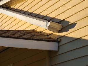Flashing was done incorrectly here; the step flashing should be under the siding, there is no gutter on the lower roof, a downspout is missing, and the kickout flashing is far too small to be effective at directing water away from the wall.