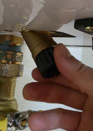 Loosen the cap to remove the water line filter on this tankless water heater.