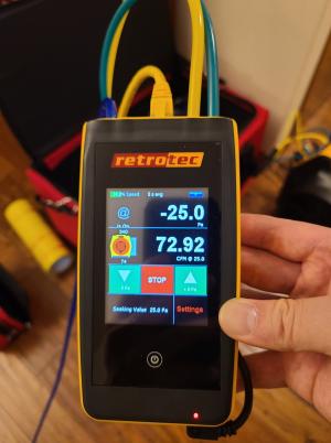 This digital manometer contains a pressure transducer used to determine pressure differences or flow rate for measuring air leakage in ducts; it is showing 72.92 cfm of leakage at 25 Pascals of depressurization of the ducts. 