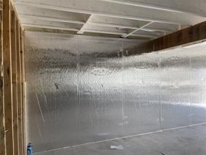 Right - Foil-faced polyisocyanurate rigid foam board is tightly installed and sealed against a concrete foundation wall prior to installing fibrous blanket insulation.