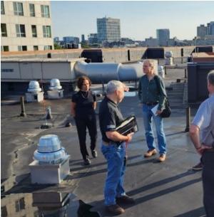 Mushroom-shaped rooftop exhaust fans provide powered central exhaust ventilation for this high-rise commercial building 