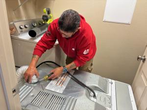 Disconnect the duct from the clothes dryer, using a screwdriver to loosen the hose clamp