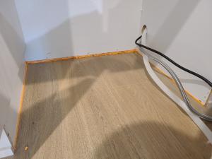 Canned spray foam can be installed with the narrow applicator tip to get a narrow bead of spray foam along this wall-to-flooring seam 