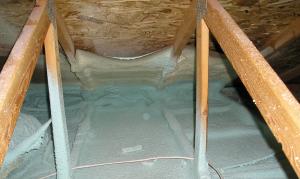 Spray foam insulates and air-seals the ceiling deck and top plates of this vented attic.
