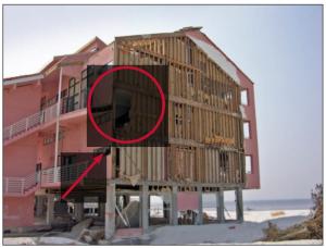 This synthetic stucco (EIFS) siding which was installed over EPS that was adhered to gypsum board failed in high winds when the gypsum board pulled over the fasteners that mechanically attached it to the studs.