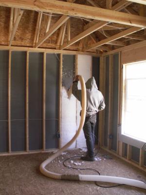Blown fiberglass insulation fills netted wall cavities 