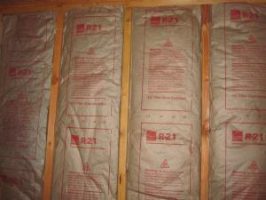 Faced fiberglass batt insulation can be stapled to the stud faces or slightly inset, but avoid compressing the batts