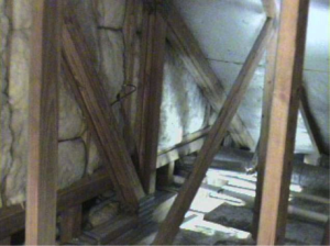 The floor cavities under this attic kneewall are completely open to the unconditioned attic space and a prime target for wind washing