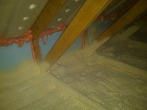 Closed-cell spray foam insulation covers the attic floor to provide a continuous air control layer