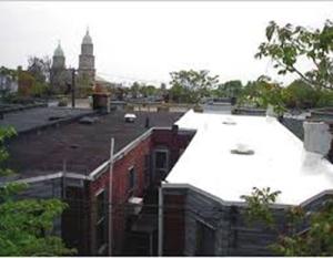 The white TPO membrane roof on the row house on the right performs extremely well at reflecting solar energy and maintaining cool surface temperatures while the black EPDM membrane roof on the left heats up rapidly in the sunlight