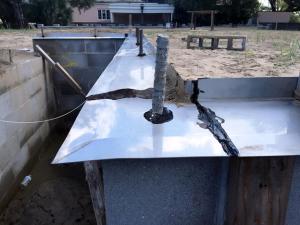 Termite shield is installed at the top of the foundation wall before installing sill plates; all seams and holes are sealed with epoxy