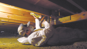 Right - An installer uses canned spray foam to air seal joints in an existing subfloor. 