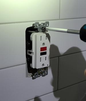 Unscrew the screws on the outlet or switch to take it out of the electrical box to access and air seal any holes in the back of the box.
