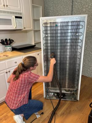 Use a vacuum with a brush attachment to remove dust and debris from condenser coils, located on the back side of this refrigerator.