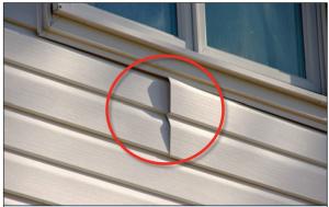Wrong – For proper detailing of vinyl around windows and other obstacles, use utility trim, punch snaplocks into siding, and do not overlap directly beneath a window. 