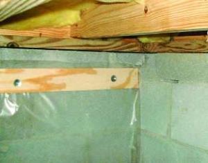 Polyethylene is being attached to the crawlspace floor and walls with plywood furring strips