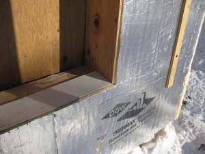 A piece of siding is used as sill extension and to provide slope in the opening for the window, which is deeper because exterior rigid foam has been added
