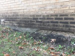 Staining and the absence of flashing at the base of an exterior brick wall