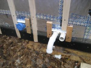Duct/pipe penetration with metal cap flashing and wood blocking for trim attachment