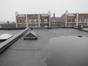 The existing flat roof before removal of membrane shows lack of slope allowing water to pool on the surface