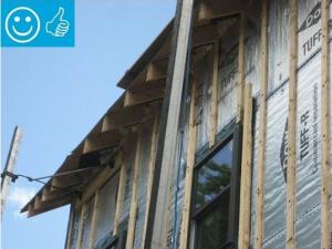 Right-Wall-insulating sheathing is extended up to roof rafters and sealed around the framing with spray foam