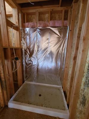 Wrong - Wall cavities behind shower are not completely filled with insulation and are lacking the solid interior air barrier. 