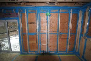 Sprayer-applied sealant seals every seam in the sheathing and framing of this double-walled home. 