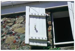 This windows in this very old building in the Virgin Islands are protected from hurricanes with robust shutters constructed of 2x4 lumber, bolted connections, and heavy metal hinges. 