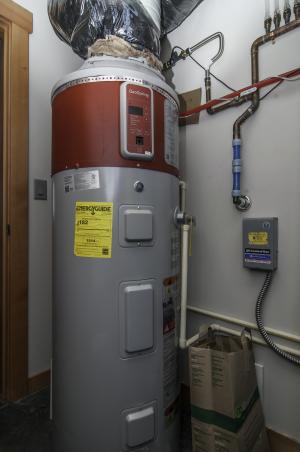Right - This 80-gallon heat pump water heater is ducted to pull heat from outside air drawn from the south side of the house and to exhaust cooled air outside on the north side of the house to efficiently heat water without impacting room temperatures.