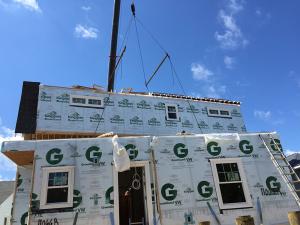 Each floor of this two-story modular home is constructed in a factory, including the 2x6, 24-inch on-center walls, R-21 fiberglass batt cavity insulation, and rigid exterior foam, housewrap, windows, and trim, then connected on site. 